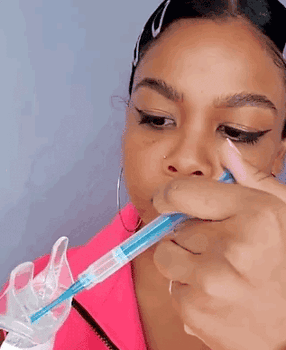 Someone demonstrating how to use the whitening kit in a gif by squeezing paste into the receptacle then putting it in their mouth and indiciating 10 minutes