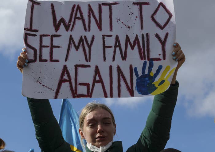 A Ukrainian  holding up a sign that says I want to see my family again
