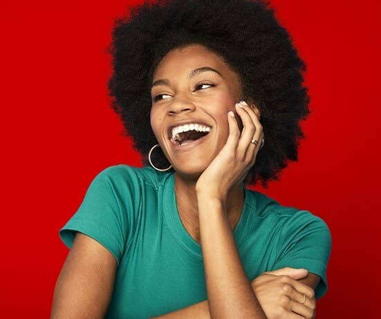 A person with her hand on her chin, laughing