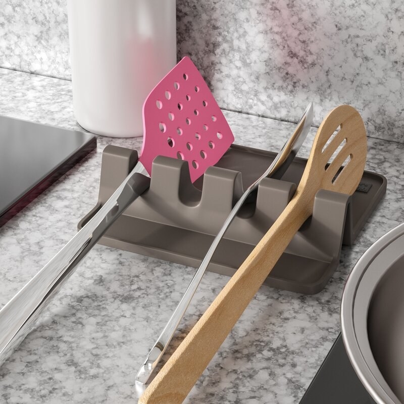 kitchen utensils resting on the gray spoon holder