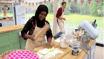 British bake off contestant pounding dough with a rolling pin
