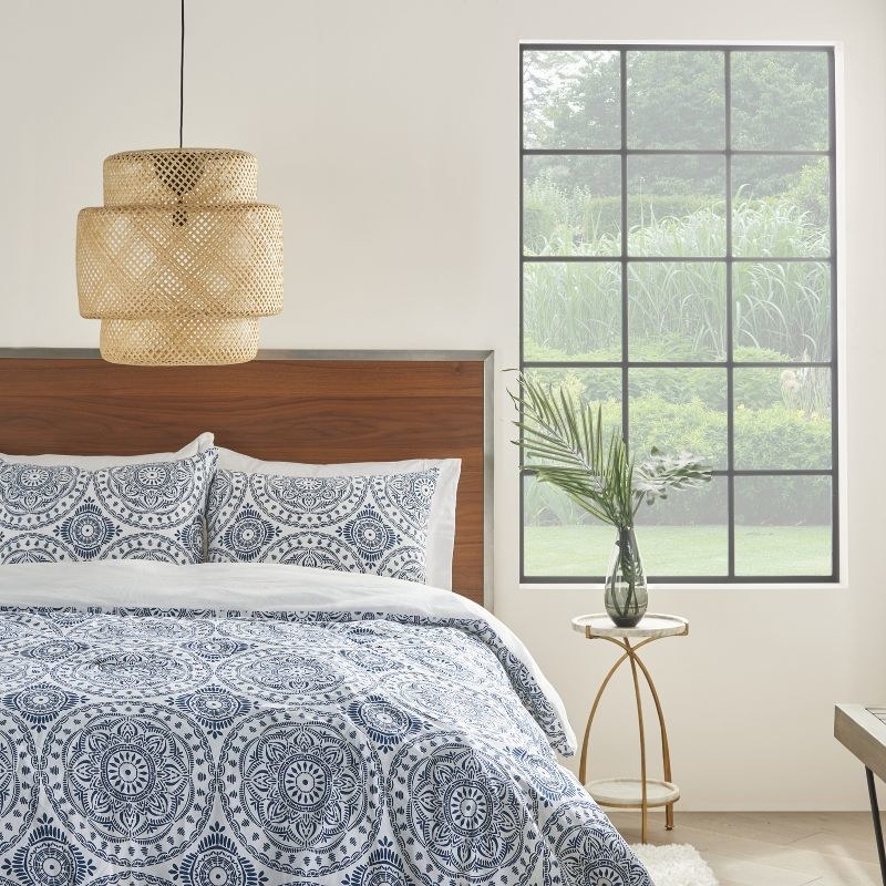 white comforter and sham pillows  with blue detailed pattern