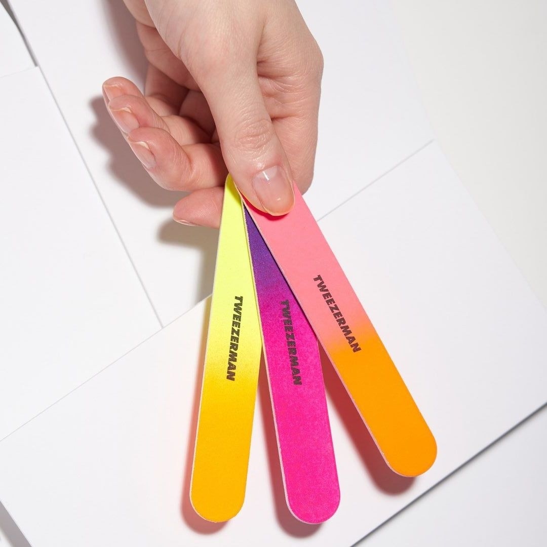 a person holding the three dual-sided nail files