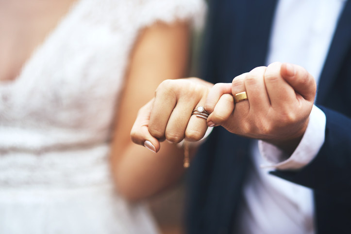 A bride and groom interlocking pinkies