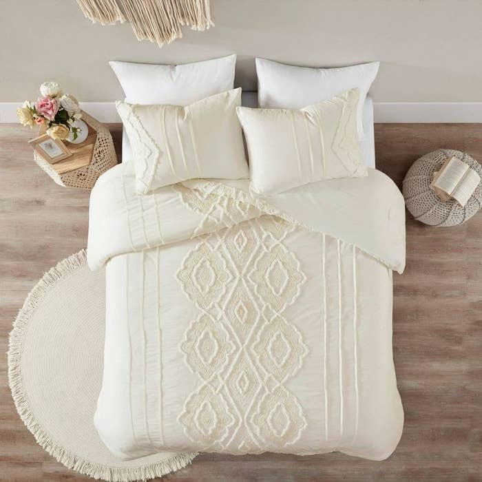 white comforter and sham pillows with vertical textured arabesque design