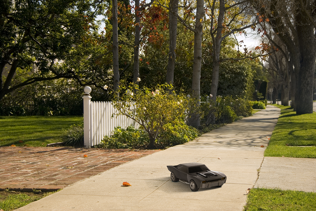 The Turbo Boost Batmobile™ RC sits on a suburban sidewalk.