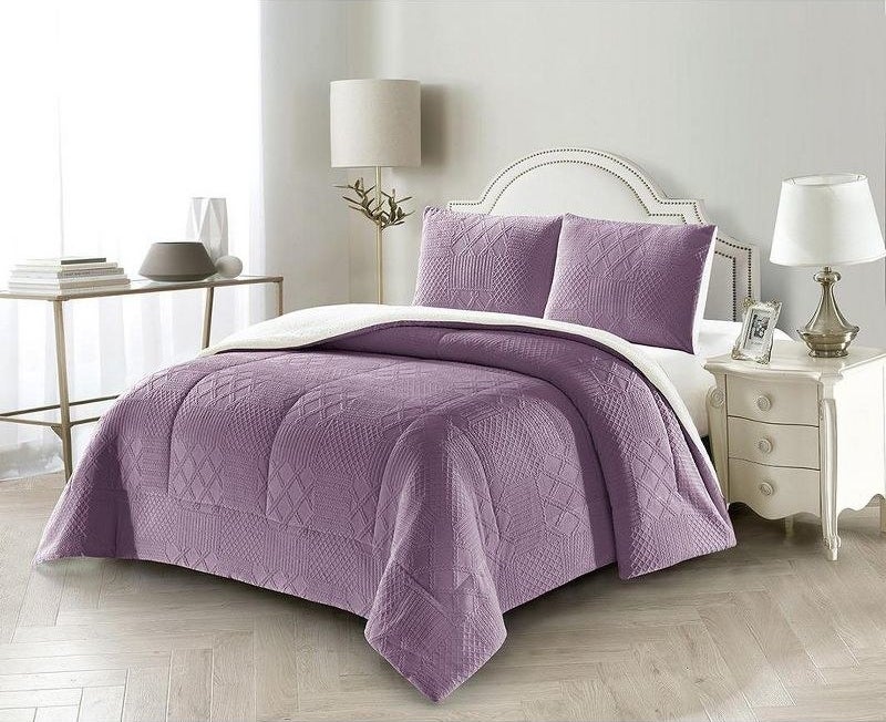 purple comforter  and sham pillows with textured design