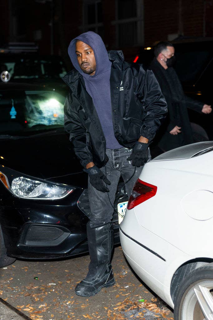 Kanye seen walking outside in a jacket and a hoodie
