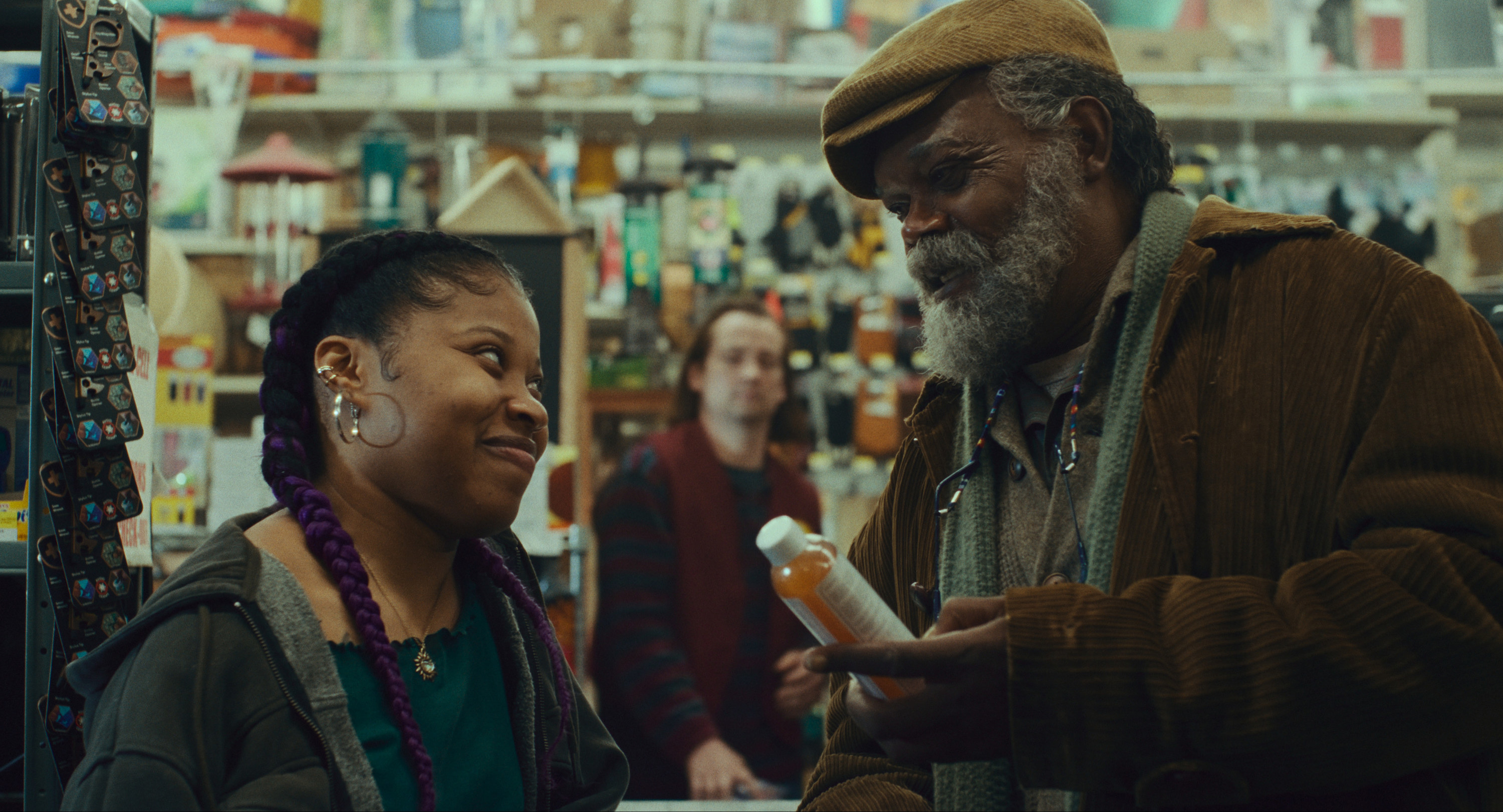 Dominique Fishback and Samuel L. Jackson look at each other in a store