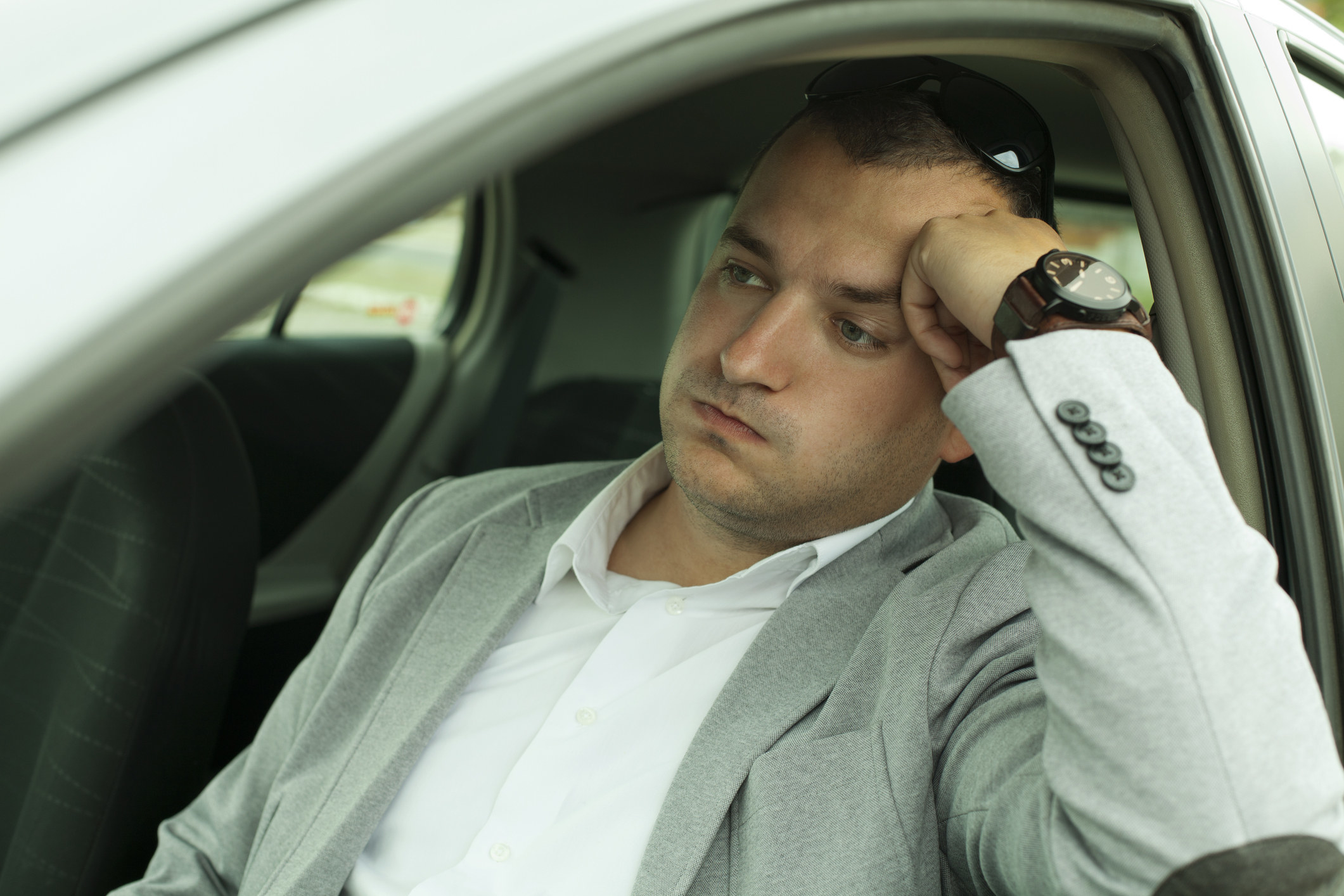 A frustrated man sits in traffic.