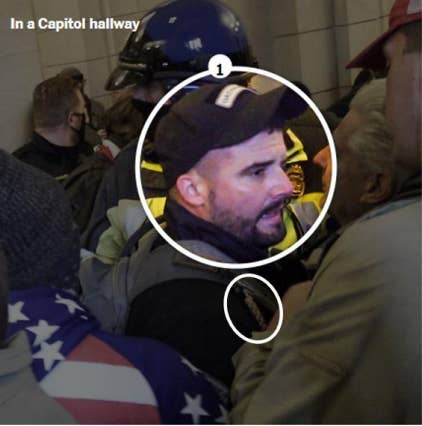 A circle is drawn around a man wearing a baseball cap, standing in a crowd of people inside the Capitol building