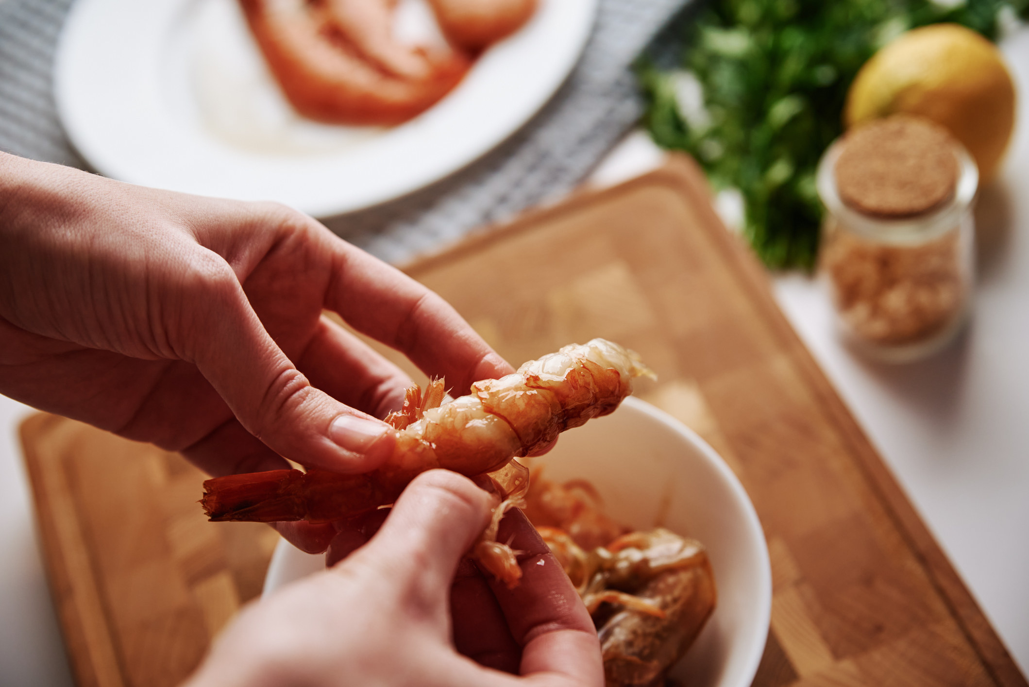 A person peeling the shells of shrimp