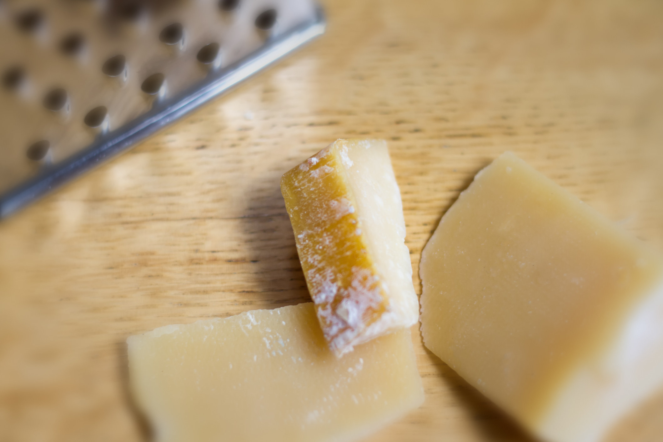 Close-up shot of Parmesan rinds on a wood cutting board