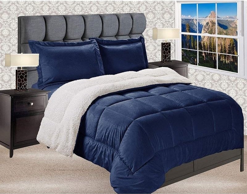 navy blue comforter and sham pillows with white sherpa material on the back