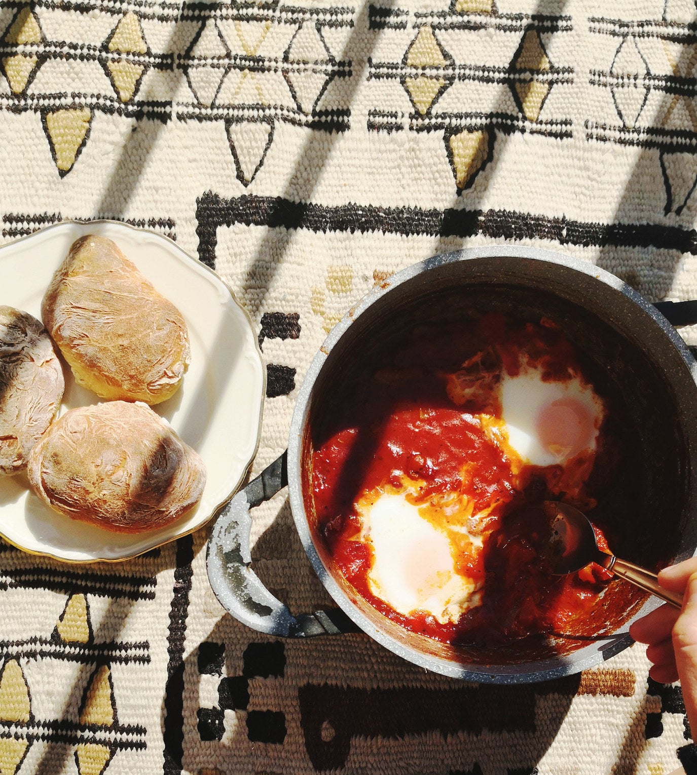 Making shakshuka in a pot with bread on the side