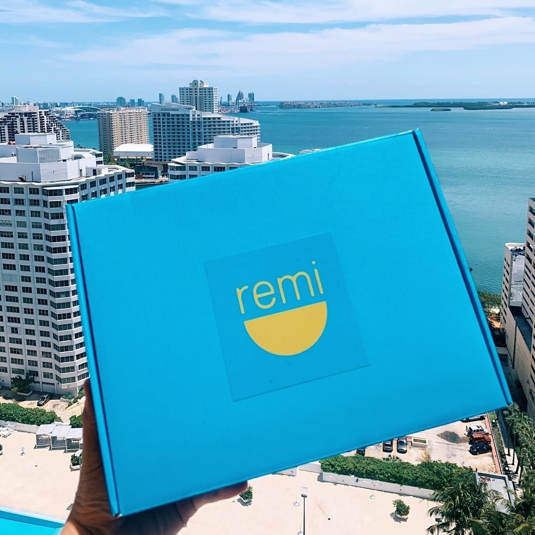 A person holding the remi box on a balcony