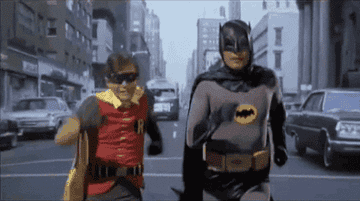 Burt Ward as Robin and Adam West as Batman run down a city street