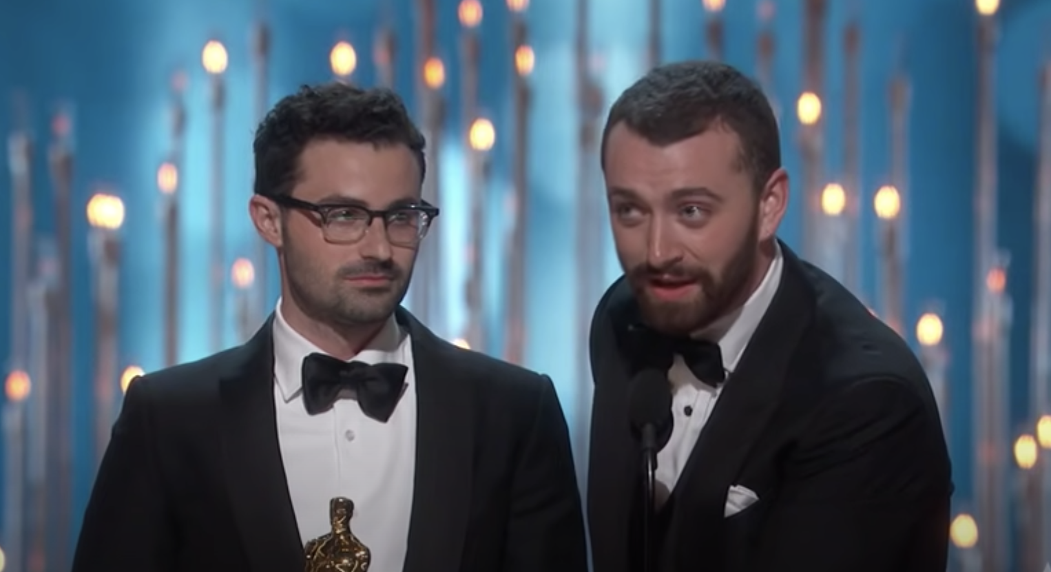 Sam Smith standing next to another man, both wearing bow ties