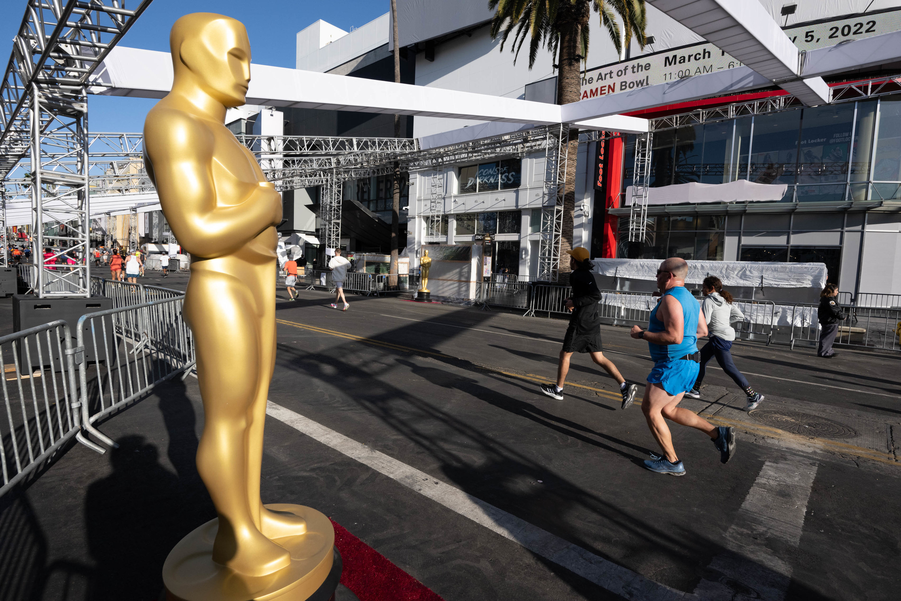Runners move head past Oscars already in place for the Academy Awards along Hollywood Blvd during the 2022 Los Angeles Marathon Sunday