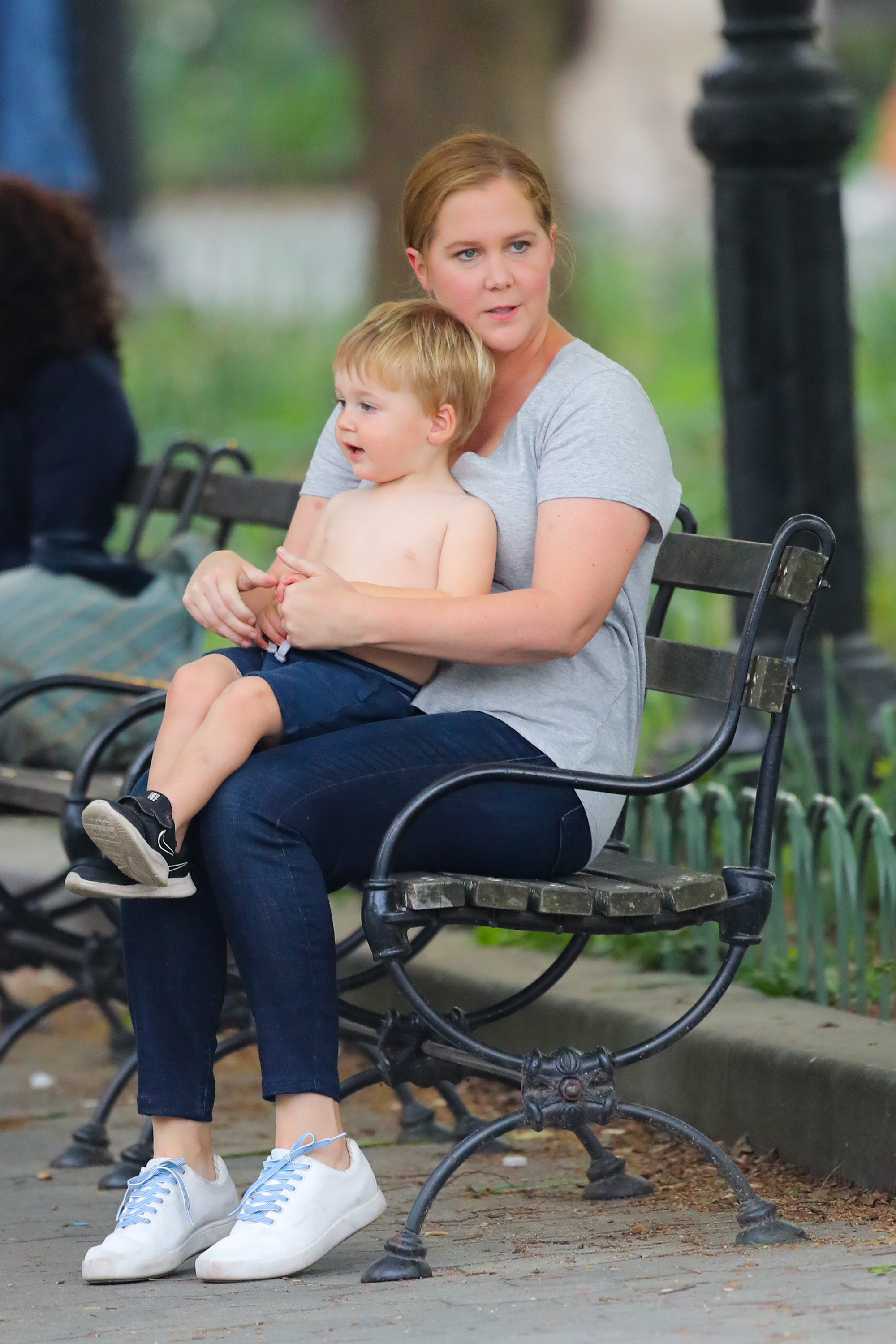 Amy sits on a bench with her child