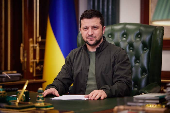 Zelenskyy sits at a desk