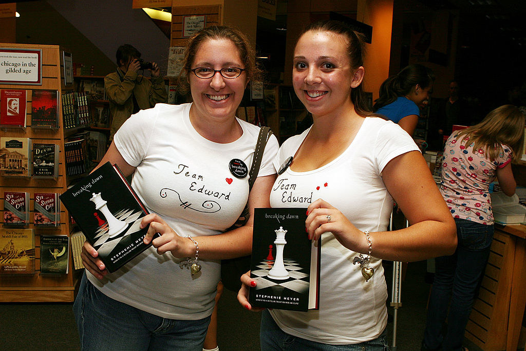 Women holding up copies of "Breaking Dawn" and wearing "Team Edward" T-shirts