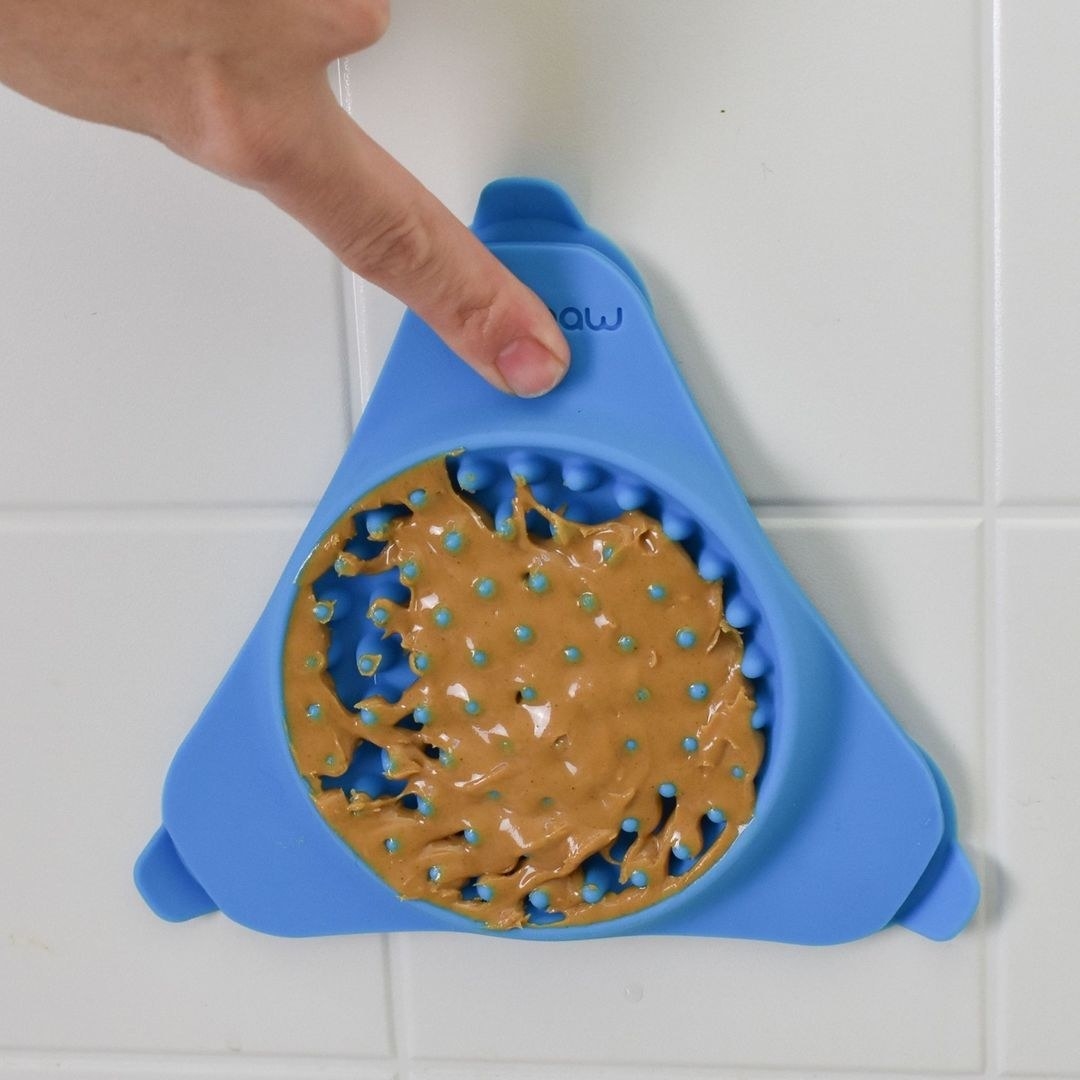 A person putting the device on their shower wall