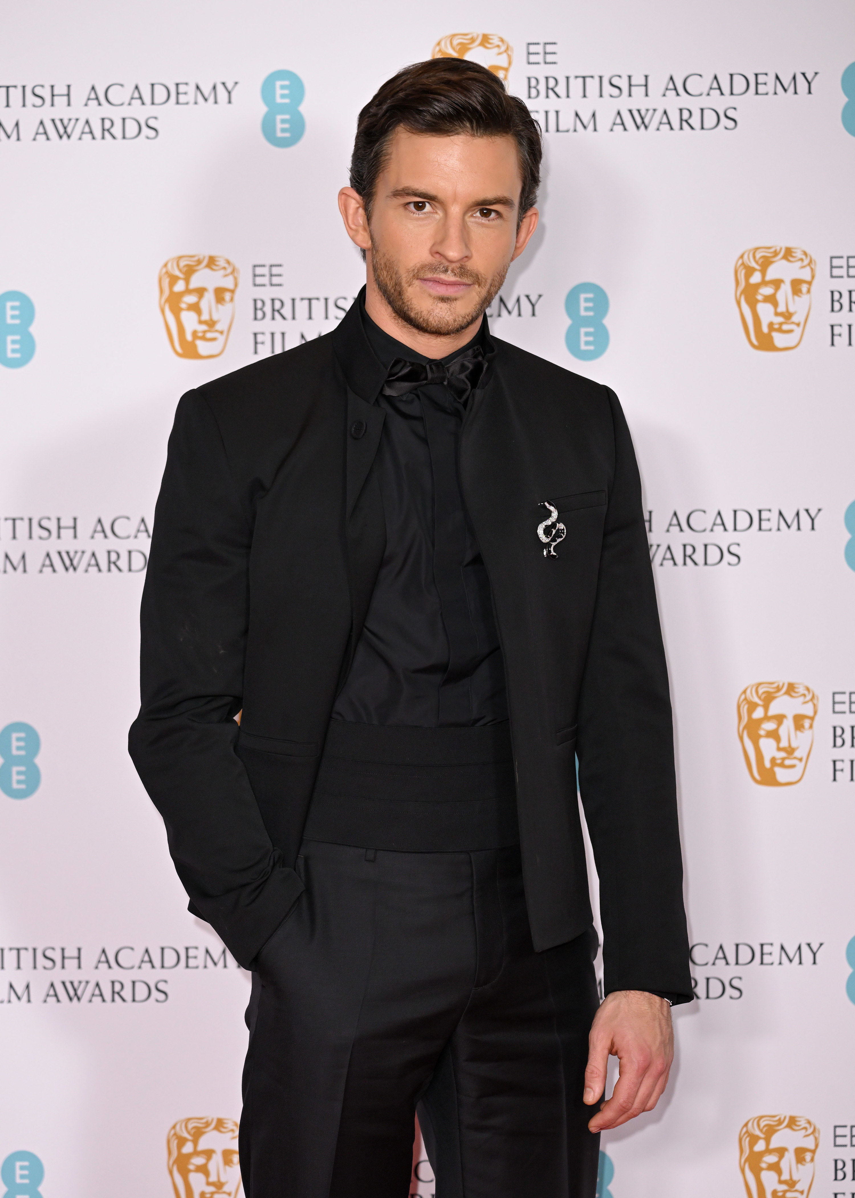 Jonathan Bailey on the red carpet with one hand in his pants pocket