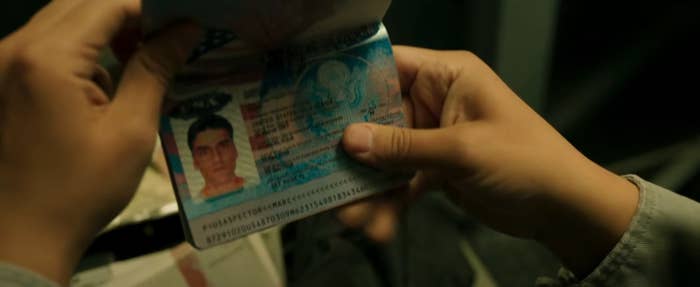 Two hands holding a passport for &quot;Marc Spector&quot;