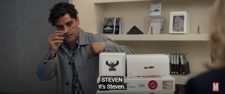 Steven holding up a name tag in a gift shop, with a subtitle reading &quot;It&#x27;s Steven&quot;