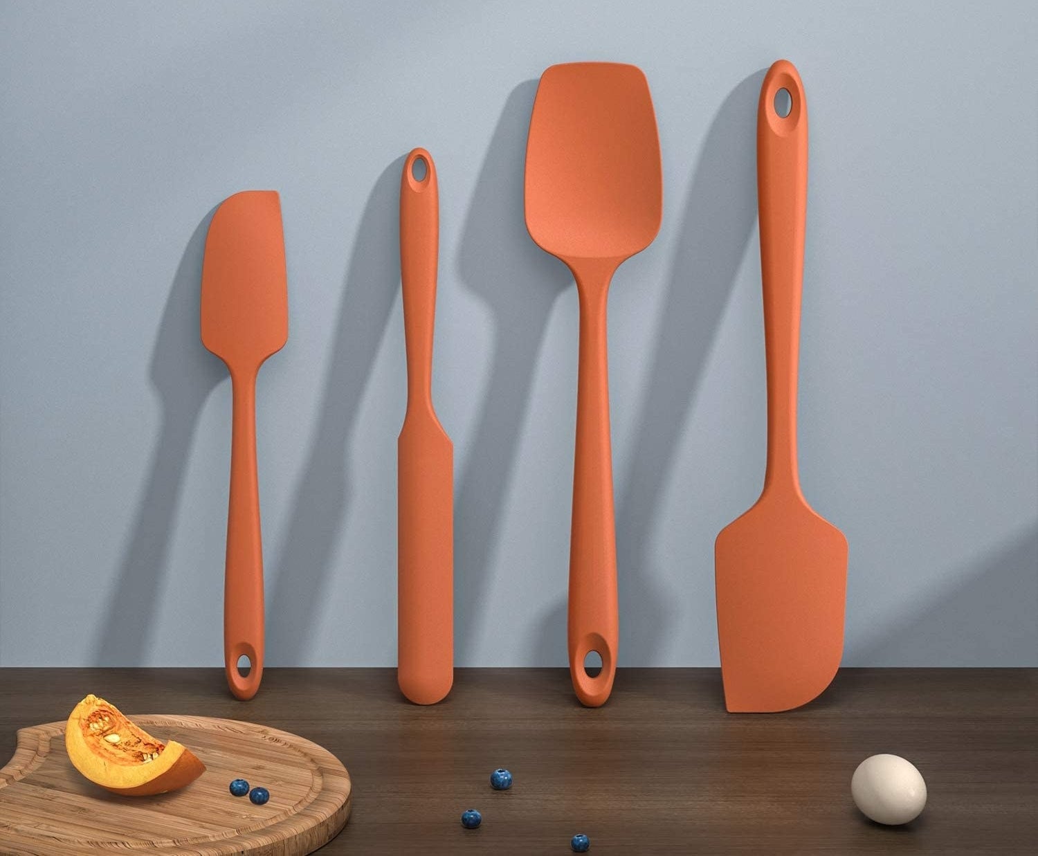 a set of silicone utensils propped up against a backsplash