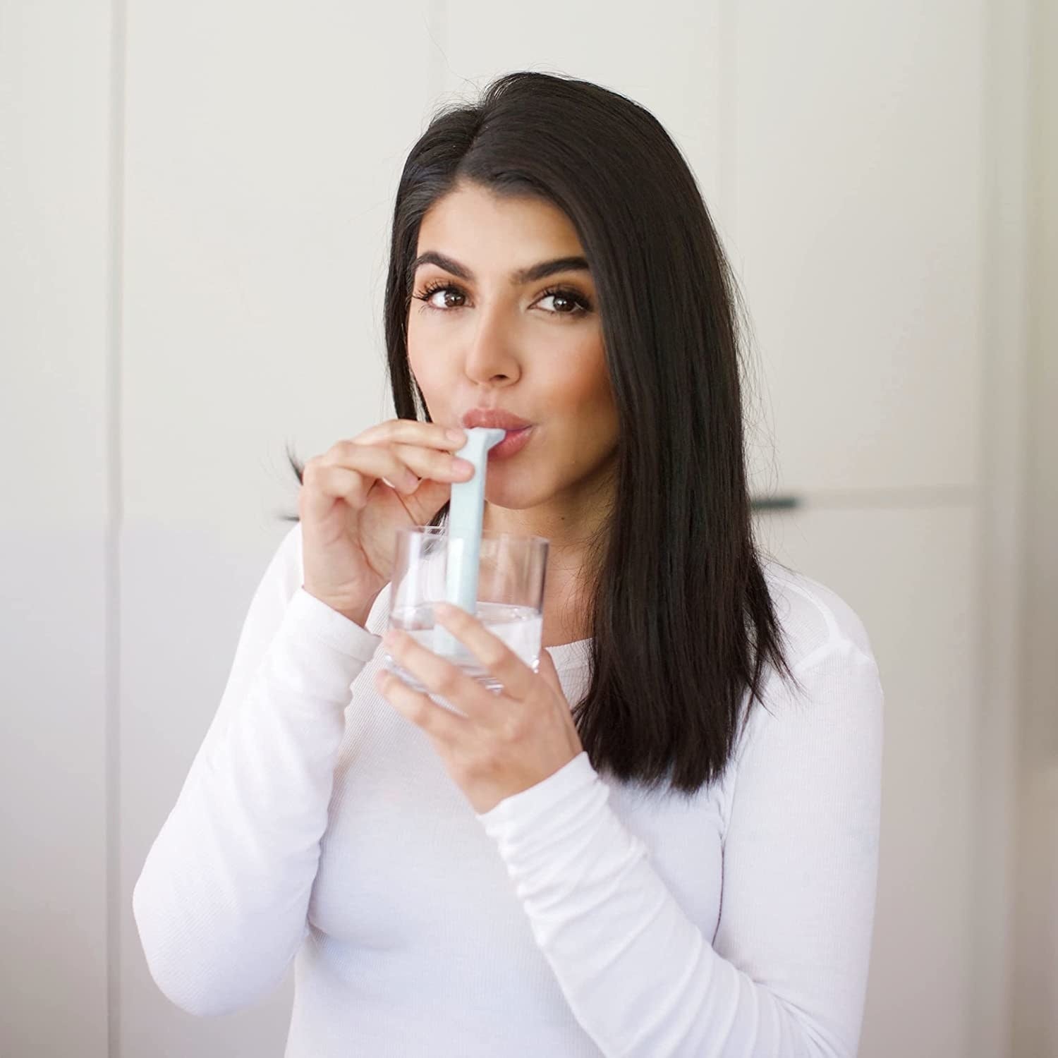 someone sipping water from a glass using the hiccup straw