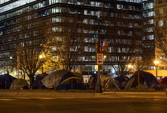 Tents are set up by a street in this nighttime photo