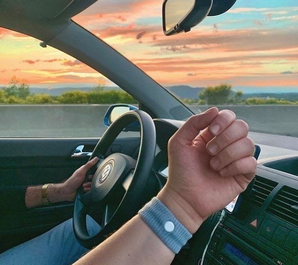 a passenger in a car wearing the wristband on their arm