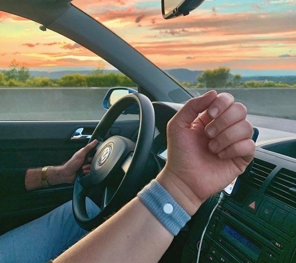 a passenger in a car wearing the wristband on their arm