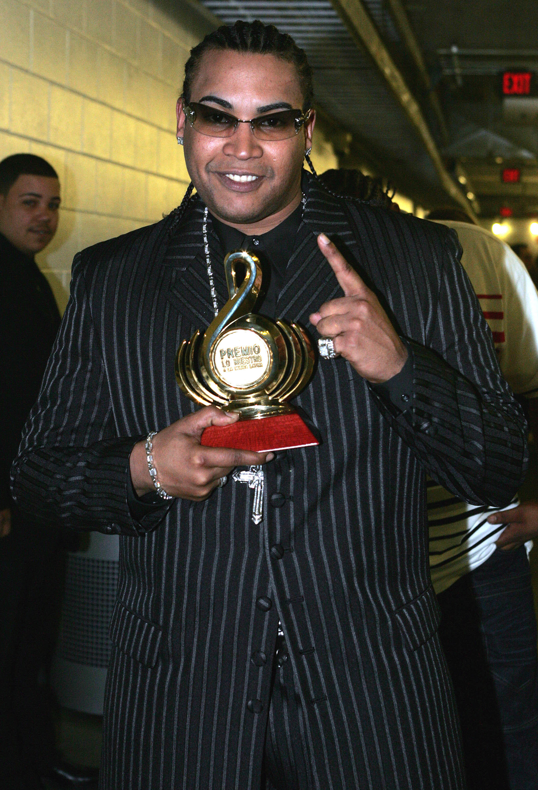 Don Omar in a suit holding an award he won from his album &quot;Last Don&quot;