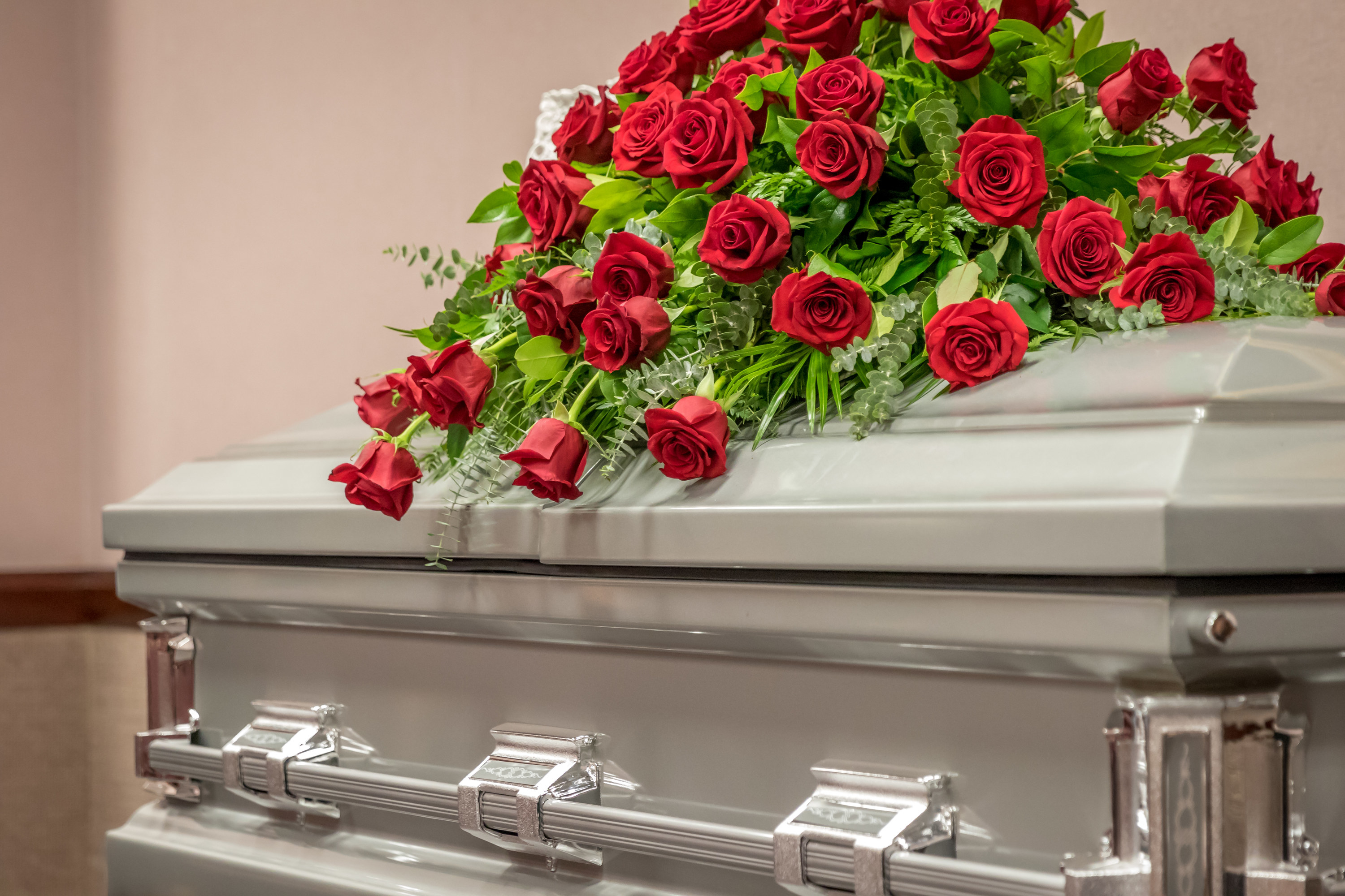 a casket with a pile of roses on top