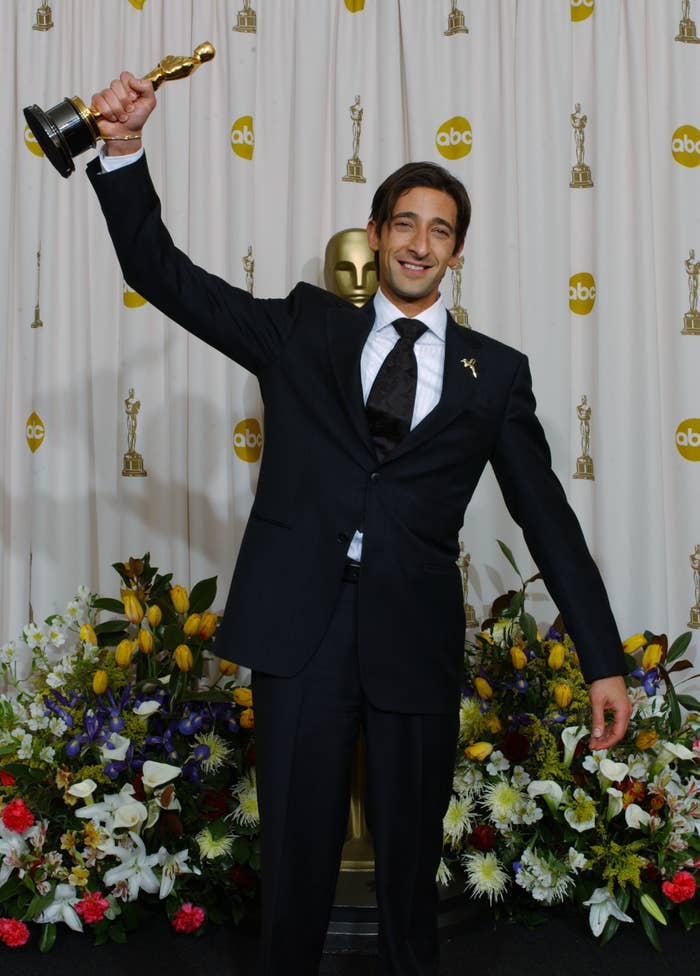 Adrien holds his award up with his hand