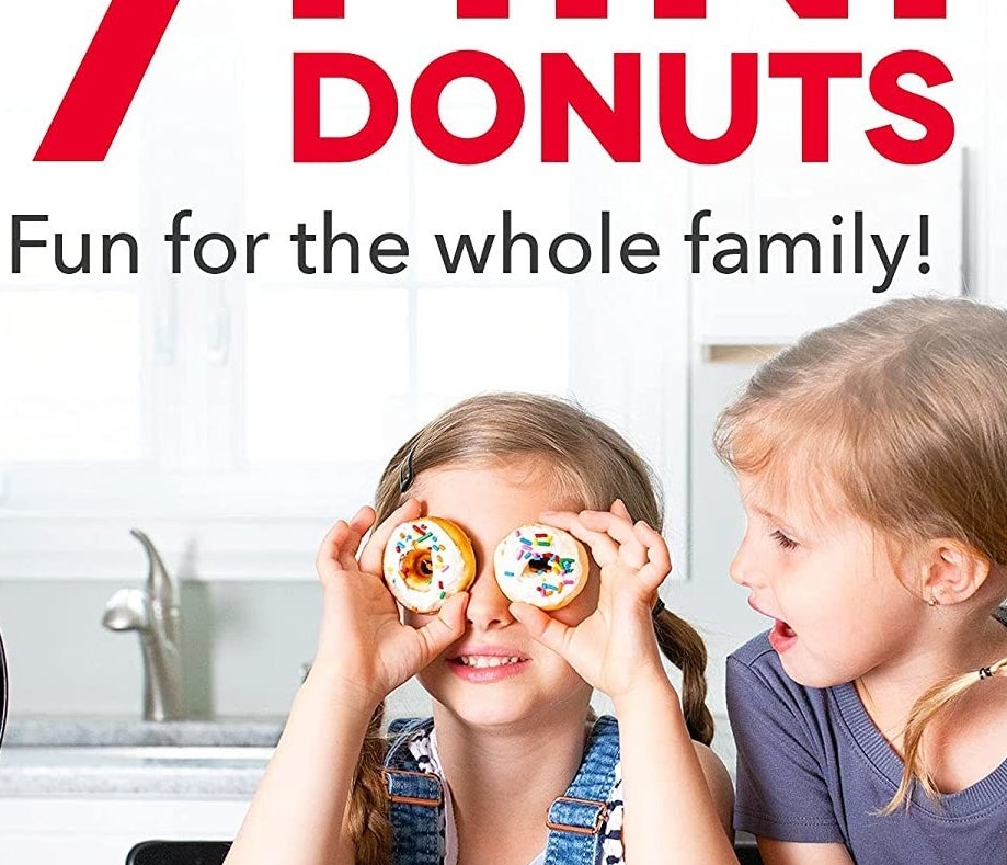 A child putting donuts up to her eyes beside the donut maker