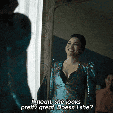 a gif from the modern-day adaptation of &quot;The Twilight Zone&quot; showing a woman looking into a mirror, waring a sparkly dress and saying &quot;I mean, she looks pretty great. Doesn&#x27;t she?&quot;