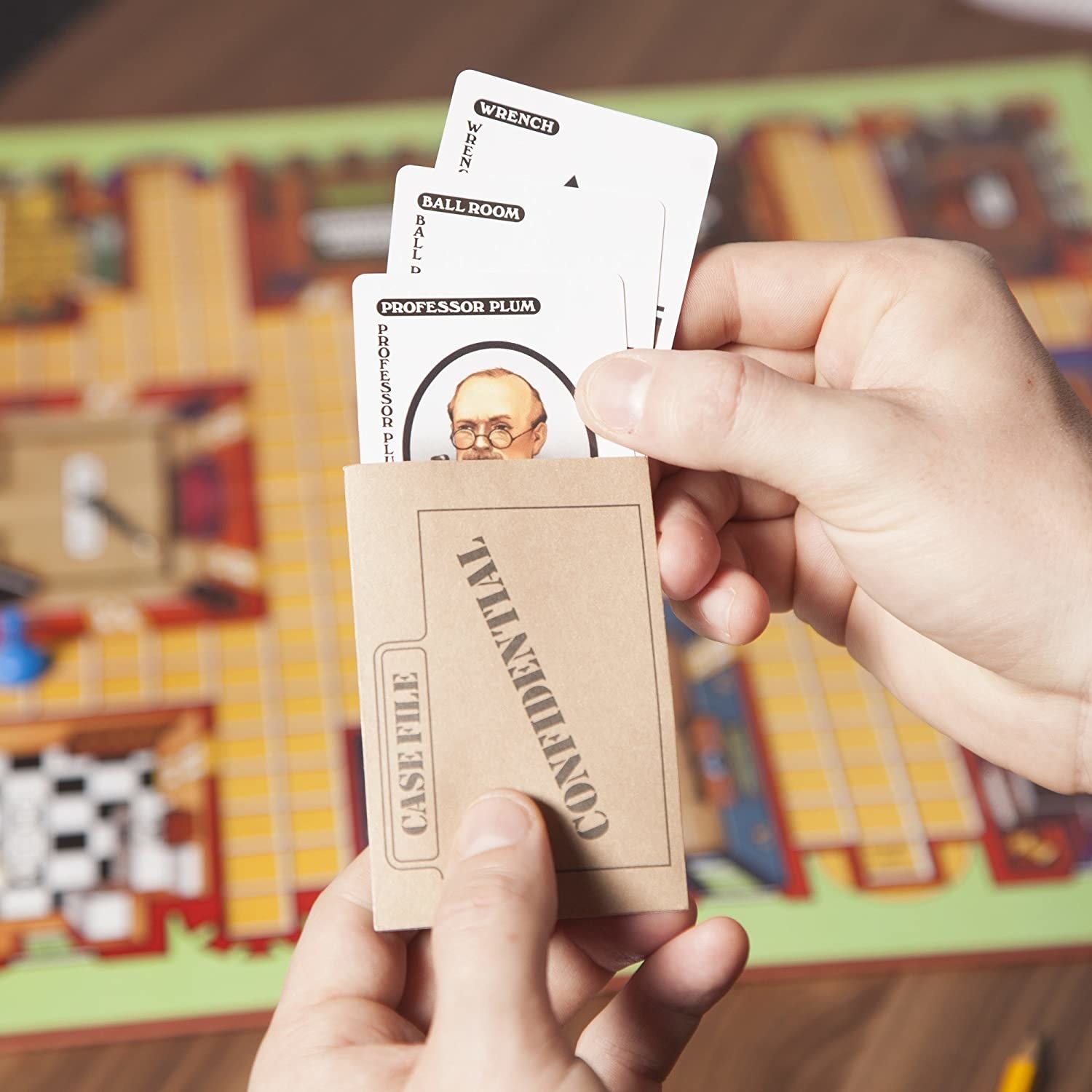 A person holding up the cards of the game over the vintage board