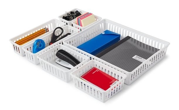 the white drawer organizers holding office supplies
