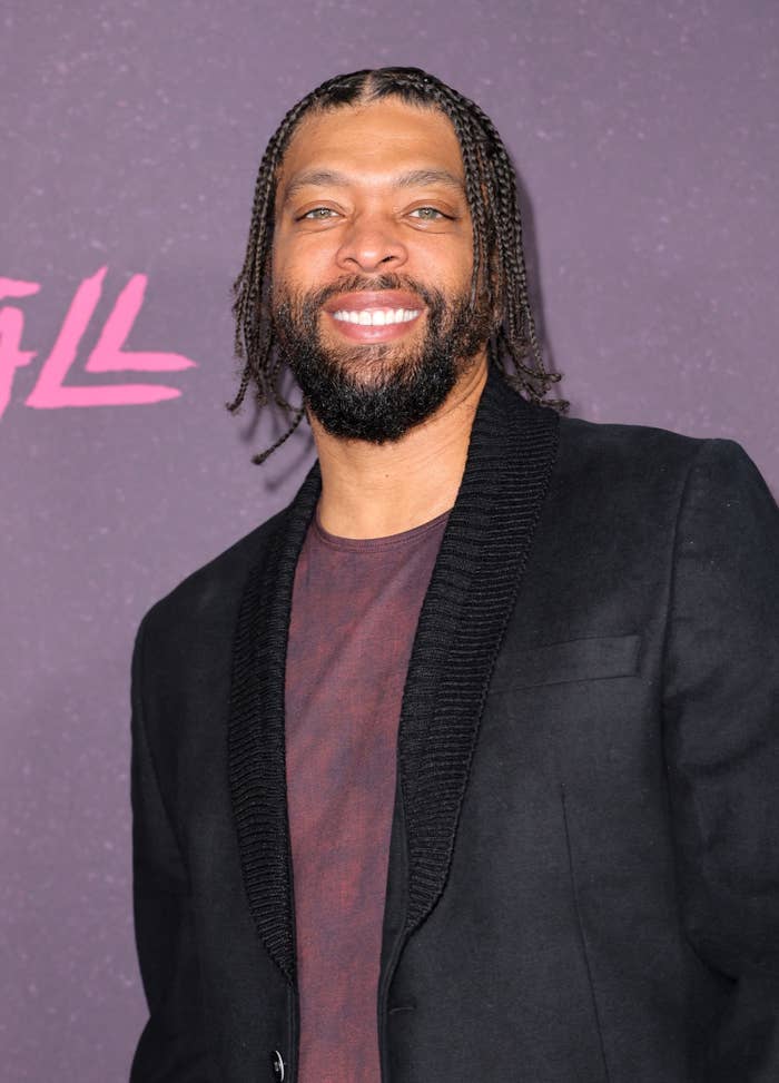 DeRay Davis poses with a smile on the red carpet at a Snowfall premiere