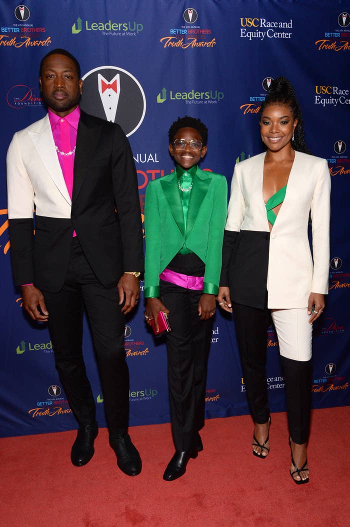 Dwyane, Zaya, and Gabrielle rocking coordinated color-blocked suits at a red carpet event