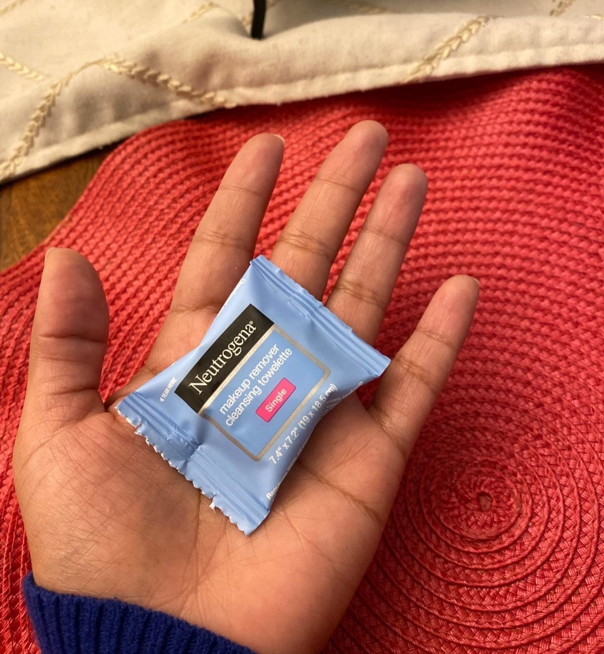 Reviewer holding a mini Neutrogena makeup remover wipe