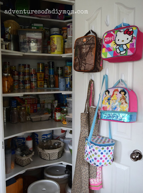 Blogger&#x27;s photo of their kids&#x27; lunchboxes hanging on hooks inside their pantry door