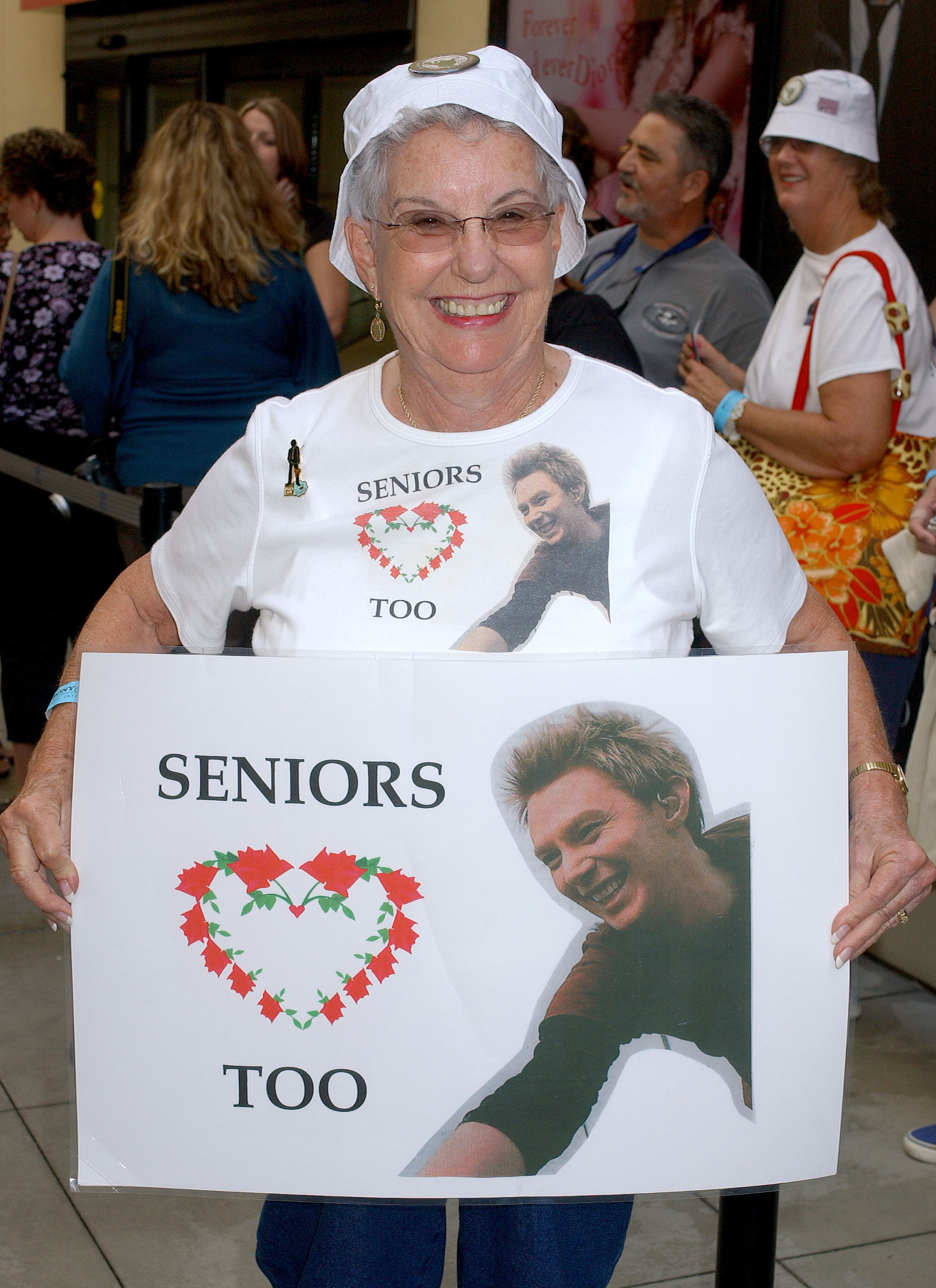 a senior woman holds up a seniors love clay sign