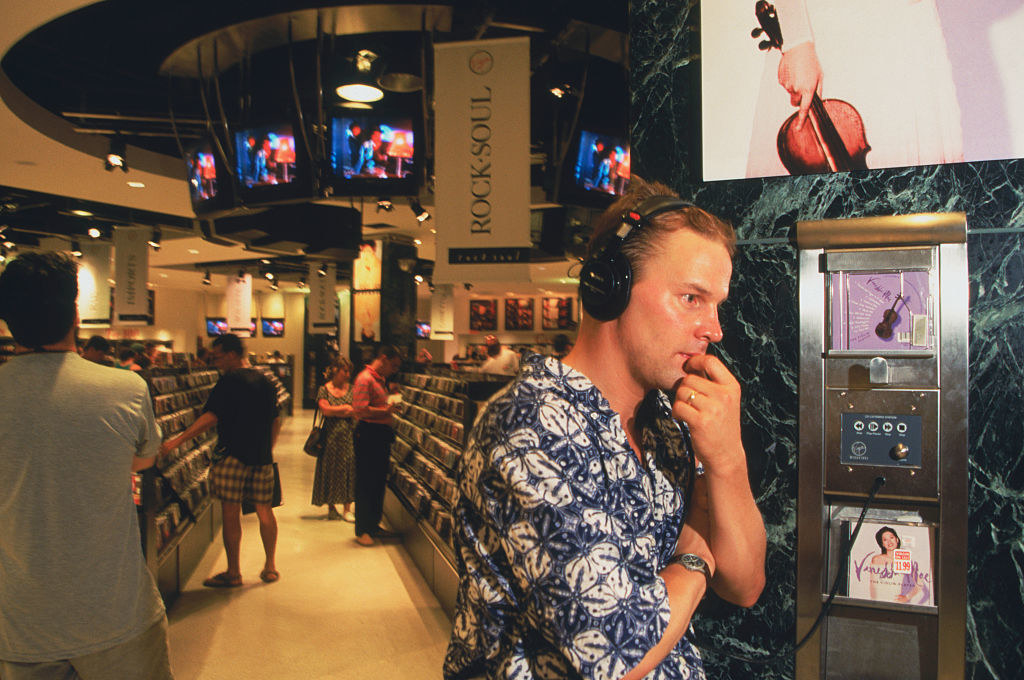 a man listens to music at a cd store