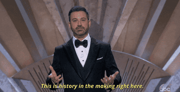 Jimmy Kimmel in a suit on stage saying &quot;This is history in the making right here.&quot;