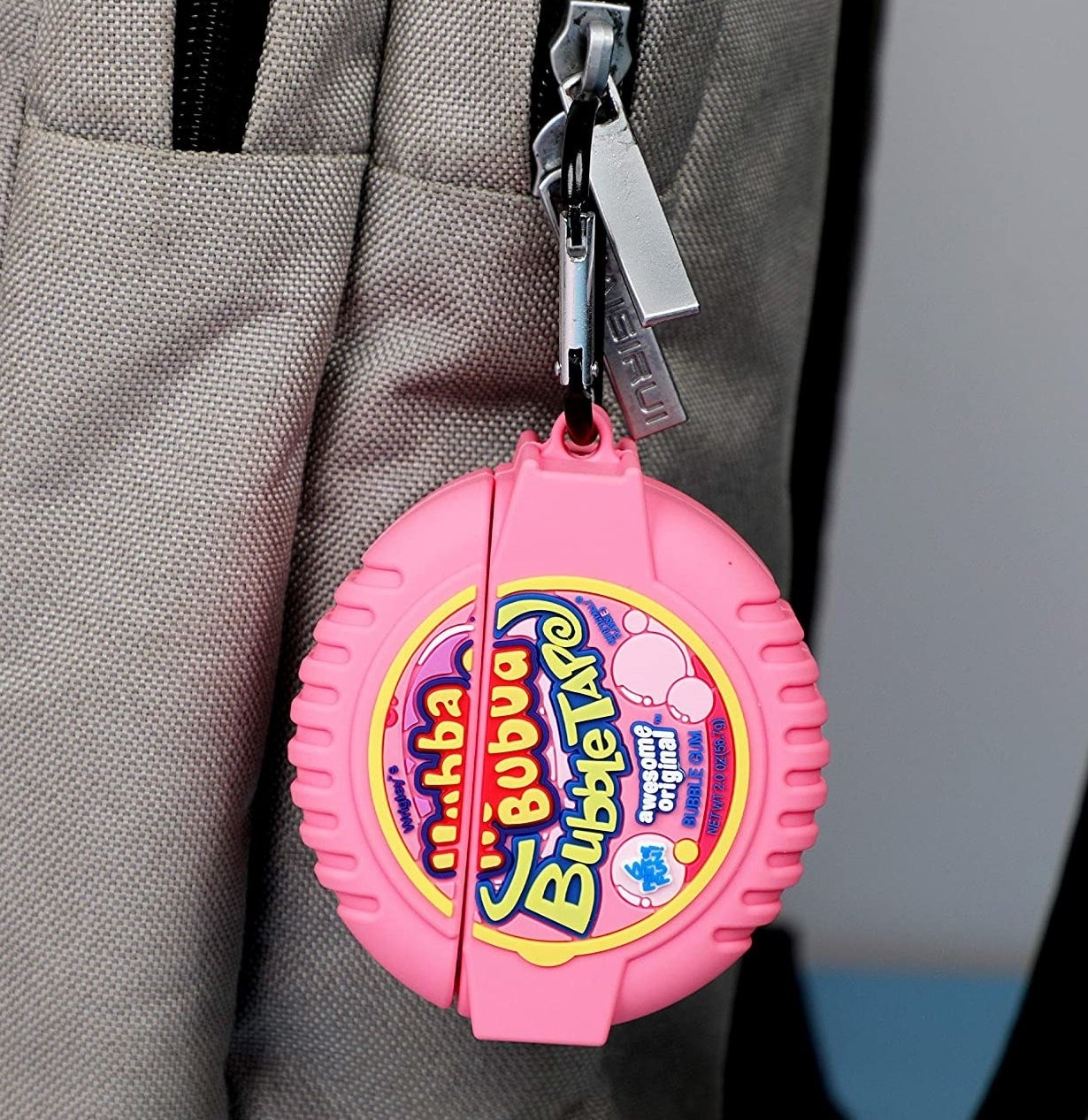 the bubblegum AirPods Case hanging from a backpack